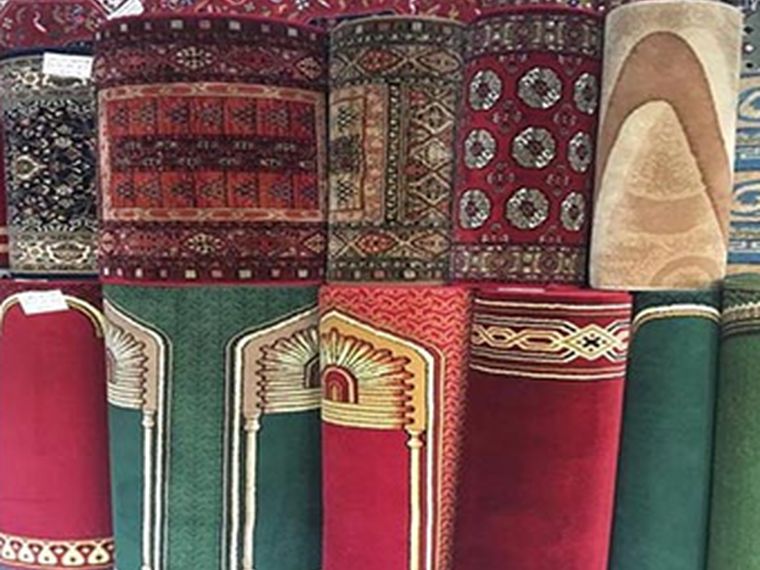 Rolled prayer rugs with mihrab arch designs
